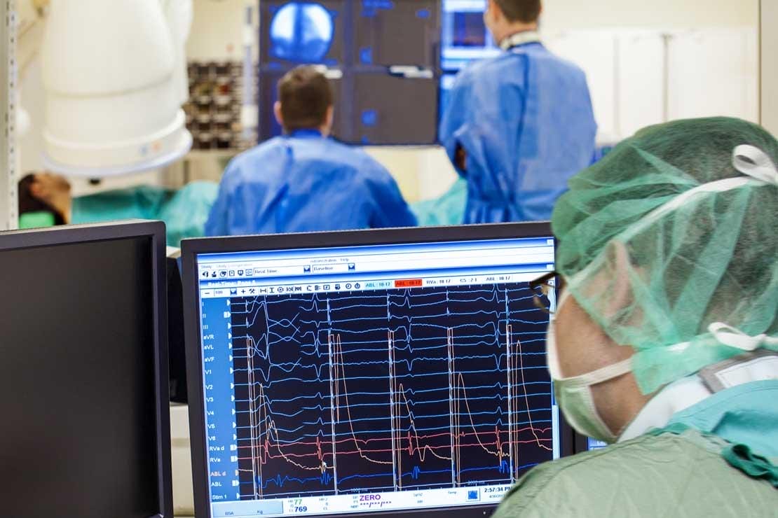 A medical expert monitors the reading during the spine surgery.