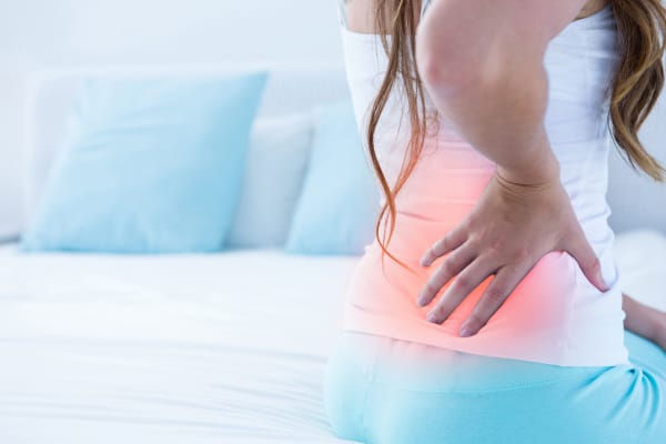 A woman with back pain which is highlighted in red.