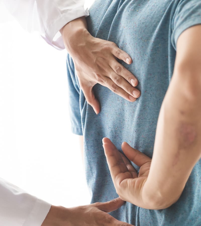 A doctor analyzing a man with low back pain.