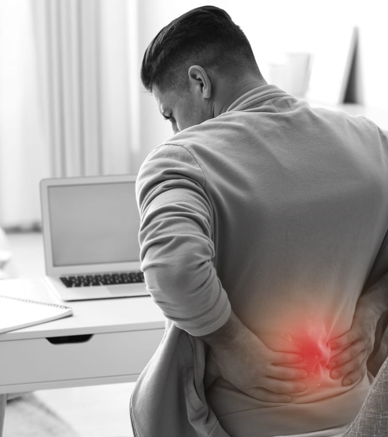 The image of a man with severe lower back pain requiring a minimally invasive lumbar decompression surgery.